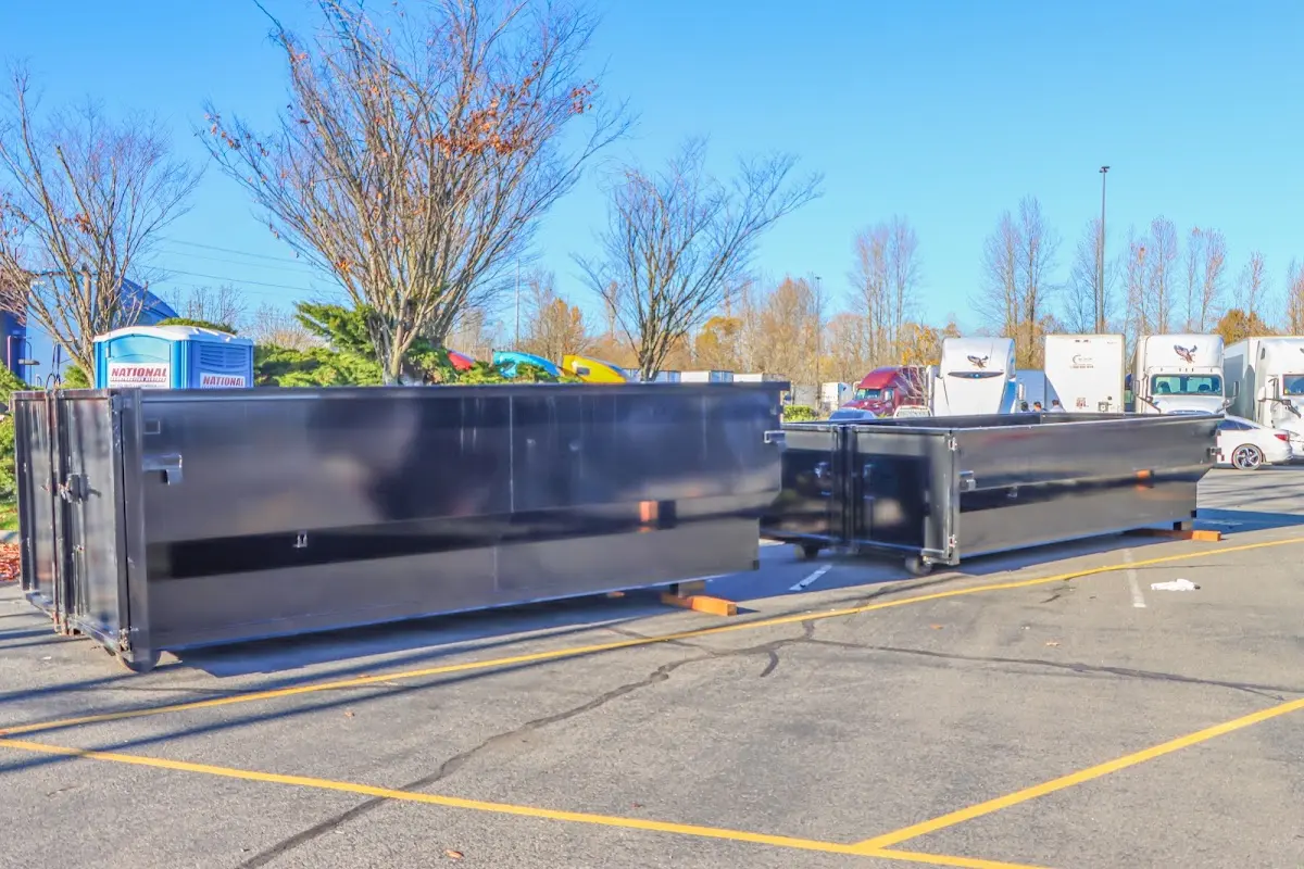 Professional dumpster rental service with roll-off container on residential driveway in Orange Beach